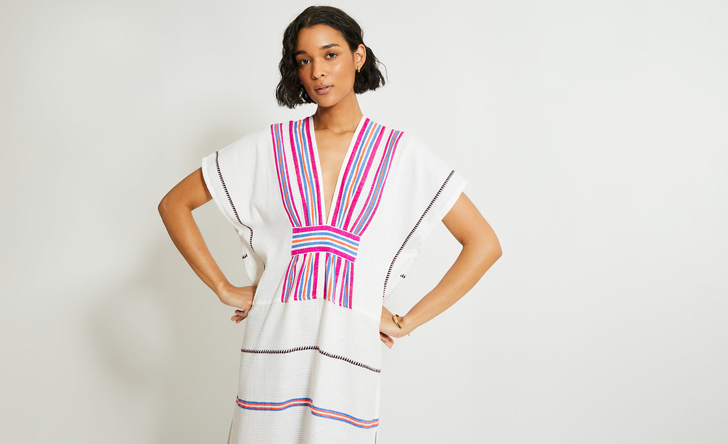 Woman standing with her hands on her hips wearing a handwoven lemlem long caftan.