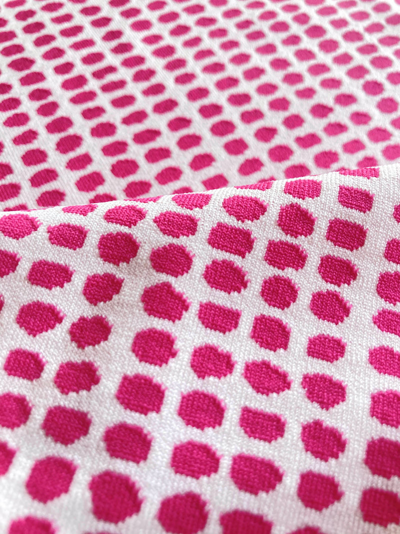 Close up on lemlem Sisay Raspberry Swim Fabric featuring vibrant raspberry dots on an ivory background, adding a lemlem twist to the classic gingham pattern