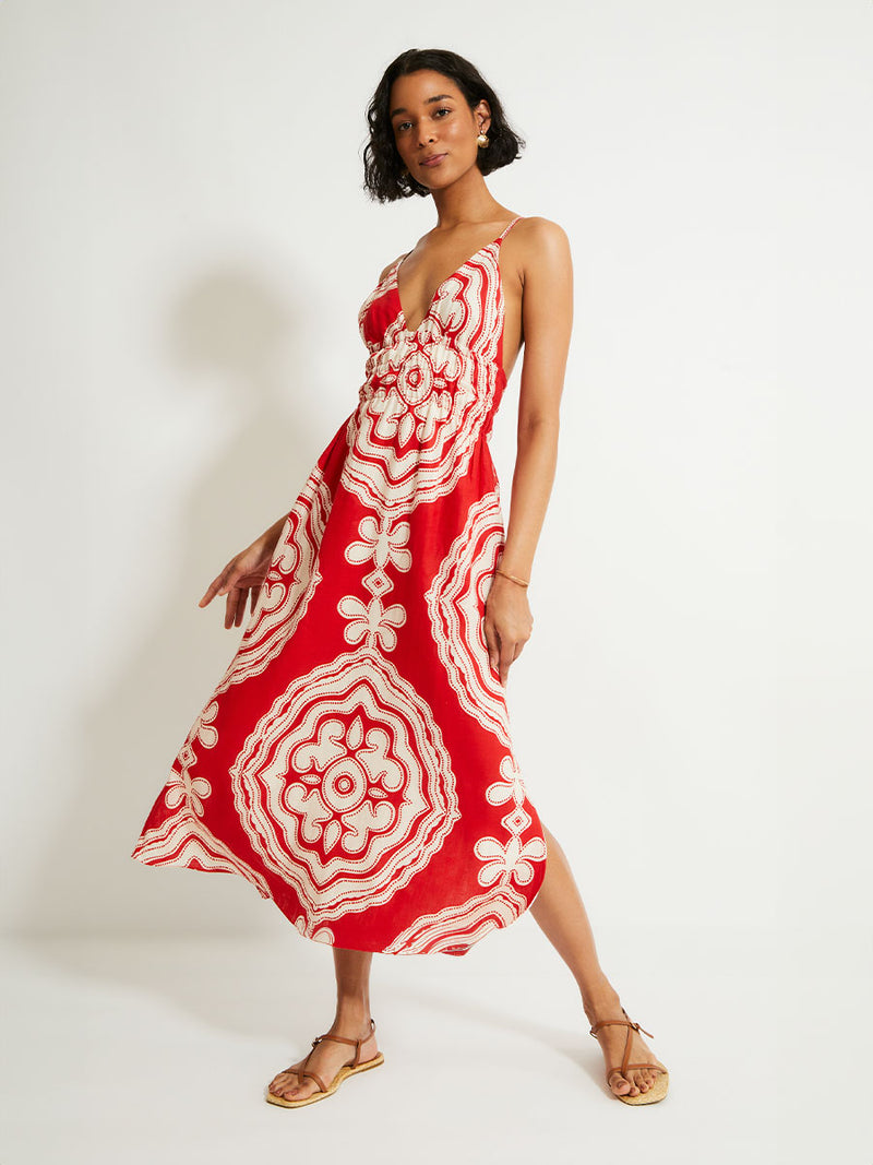  Woman Standing Wearing lemlem GETE Triangle Dress featuring custom-designed print inspired by ancient architectural patterns in rich, vibrant red and creamy ivory colors.