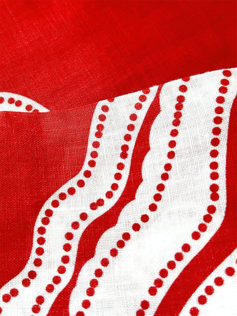 Close up on lemlem NIKU Red Fabric featuring custom-designed print inspired by ancient architectural patterns in rich, vibrant red and creamy ivory colors.