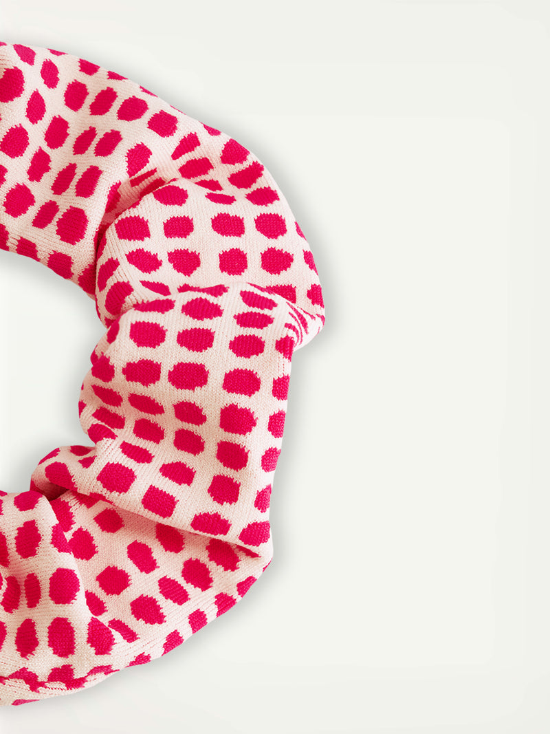 Close up on lemlem Lishan Scrunchie featuring vibrant raspberry dots on an ivory background