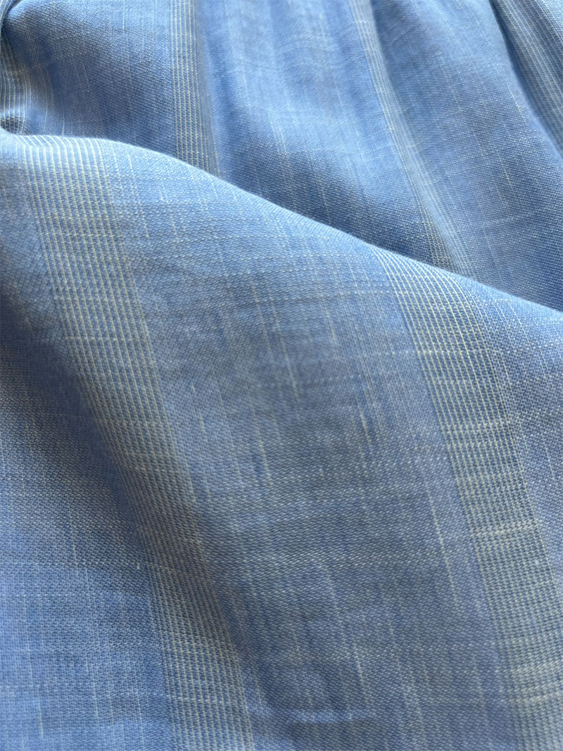close up on lemlem bekele blue fabric featuring soft, lightweight material with a subtle stripe pattern in two shades of blue.