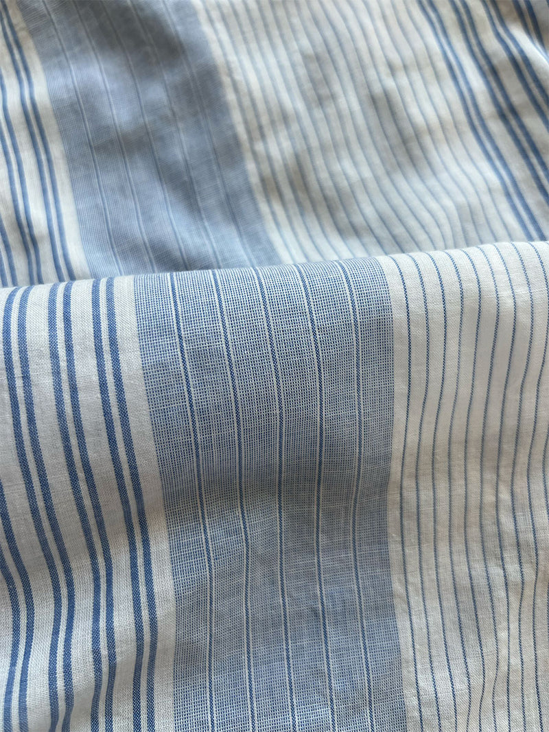 close up on lemlem dera blue fabric featuring an elegant, light blue and white striped design, perfect for a crisp and fresh look.