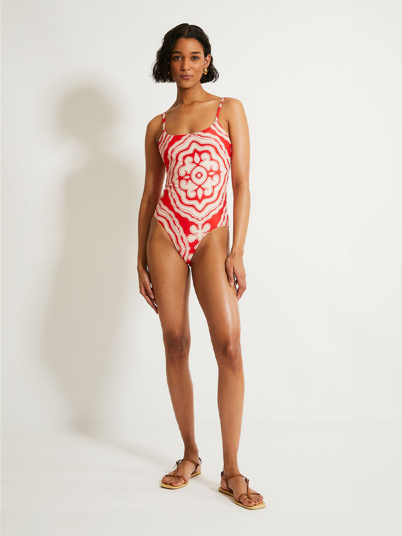 Woman Standing Wearing lemlem ELENE One Piece swimsuit featuring custom-designed print inspired by ancient architectural patterns, blending the classic with the contemporary. 