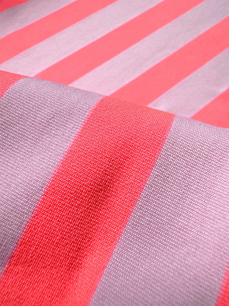 Close up on lemlem  Chireti Pink Fabric featuring  bold and vibrant neon orange red, accented by soft rose stripe 