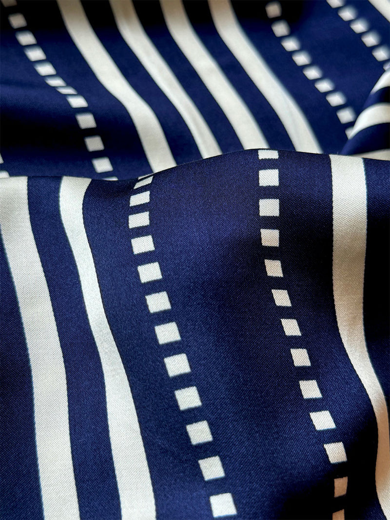 close up on lemlem Eshe Navy Fabric  featuring a classic navy background with ivory stripes and dots