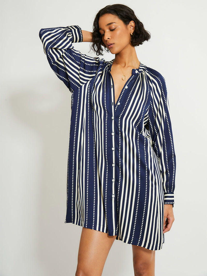 Woman Standing Wearing lemlem Meaza dress featuring a classic navy background with ivory stripes and dots