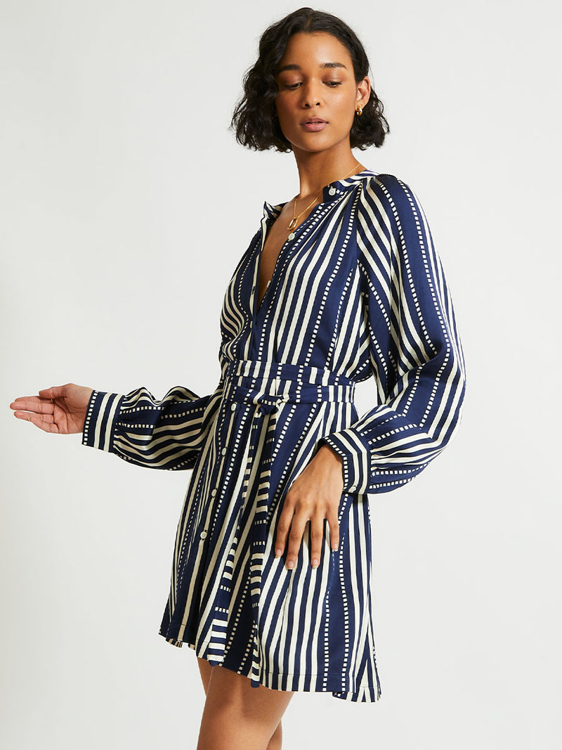 Woman Standing Wearing lemlem Meaza dress featuring a classic navy background with ivory stripes and dots