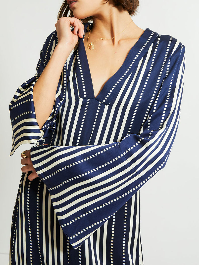 Close up on a Woman Standing  Wearing lemlem Theodora dress featuring a classic navy background with ivory stripes and dots