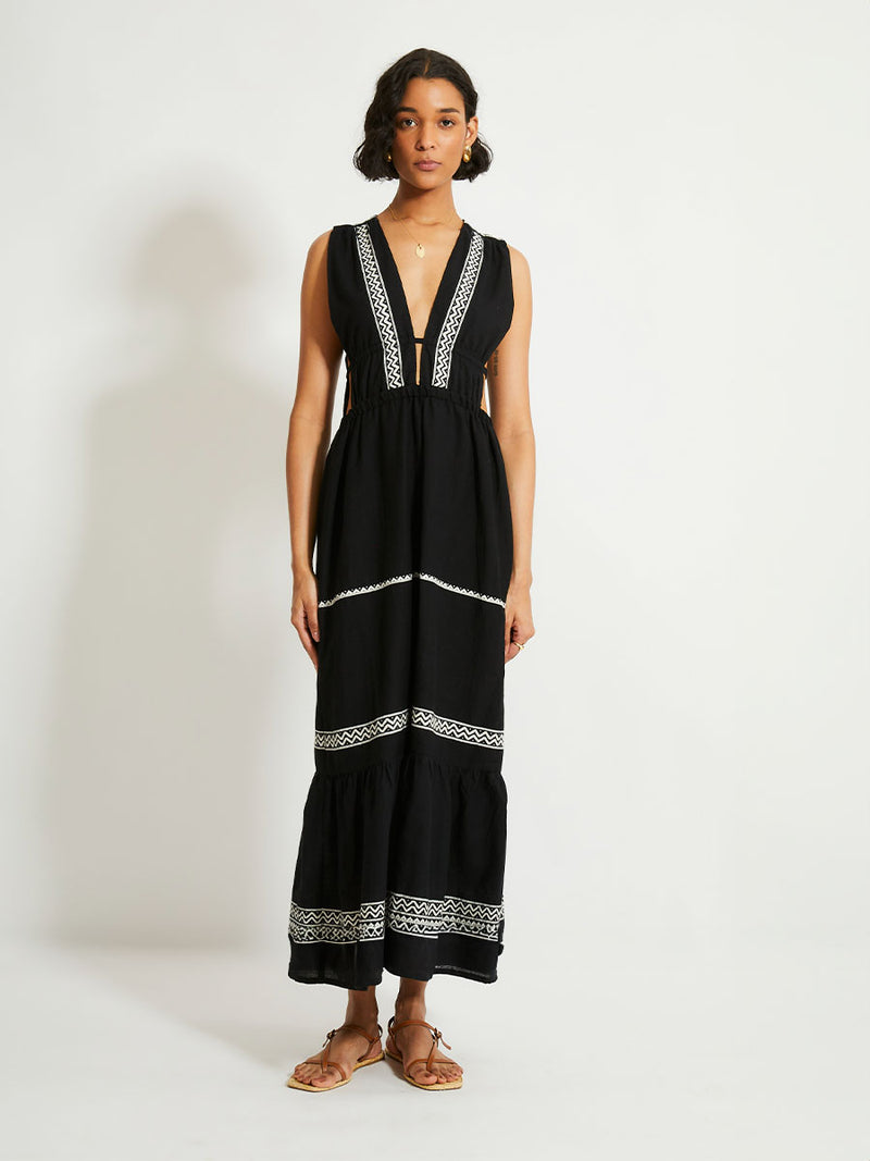 Woman Standing Wearing lemlem LELISA Dress Featuring rich black background with intricate cream Tibeb border pattern