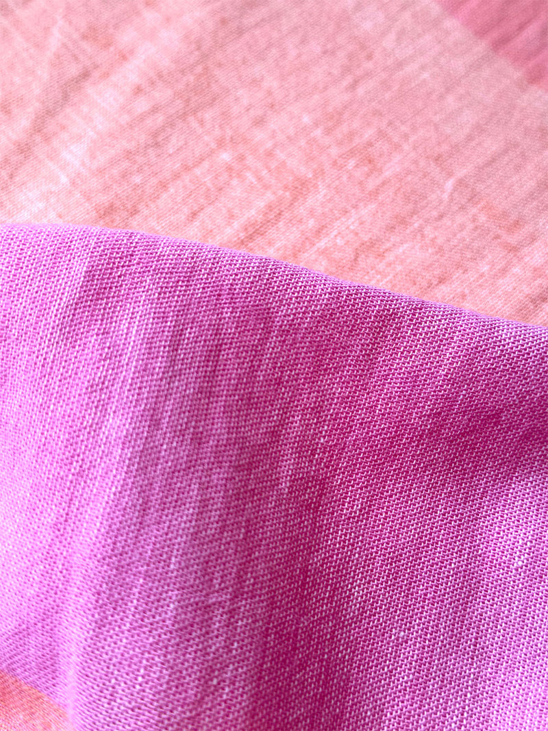 Close up on lemlem Nefas Peach gauzy fabric with a beautiful ombre color block of pink, blush, and peach colors.