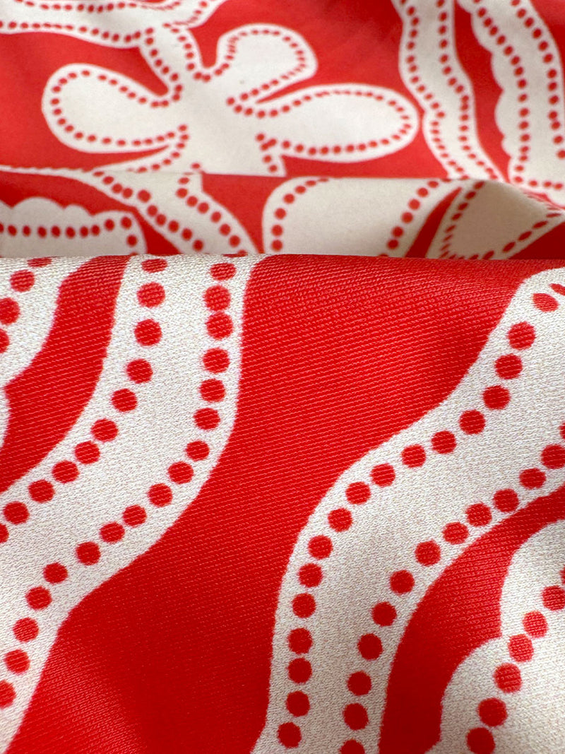 Close up on lemlem Niku Red fabric featuring  custom-designed print inspired by ancient architectural patterns, blending the classic with the contemporary. 