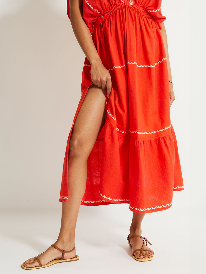 Close up on Woman's Legs Standing Wearing lemlem LELISA Dress featruing an intricate Tibeb pattern in rich red and vanilla colors