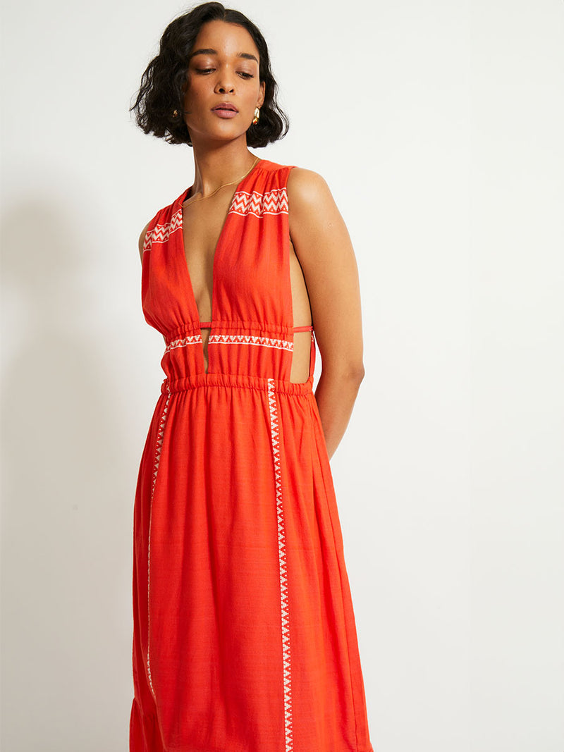 Woman Standing Wearing lemlem LELISA Dress featuring an intricate Tibeb pattern in rich red and vanilla colors