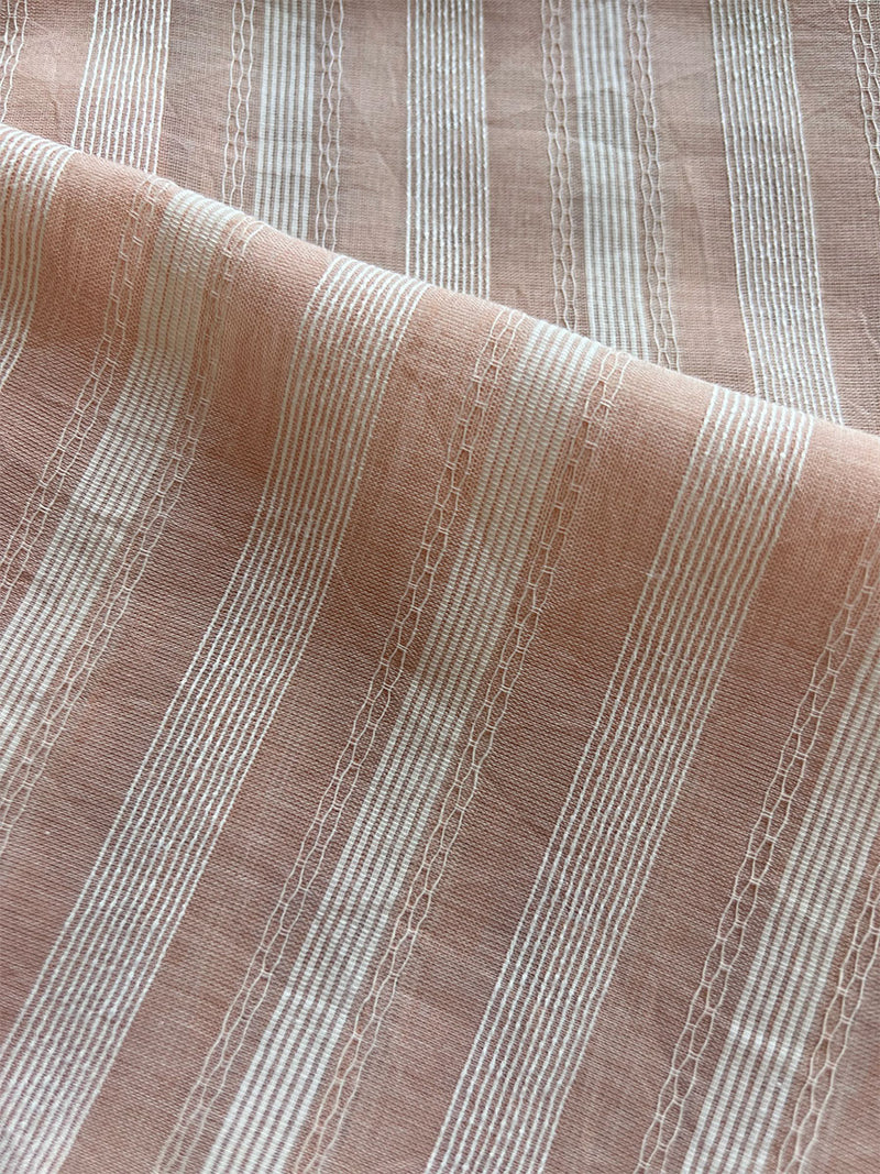 close up on lemlem nefasi fabric featuring featuring elegant soft rose stripe pattern offering a touch of classic charm and romantic flair
