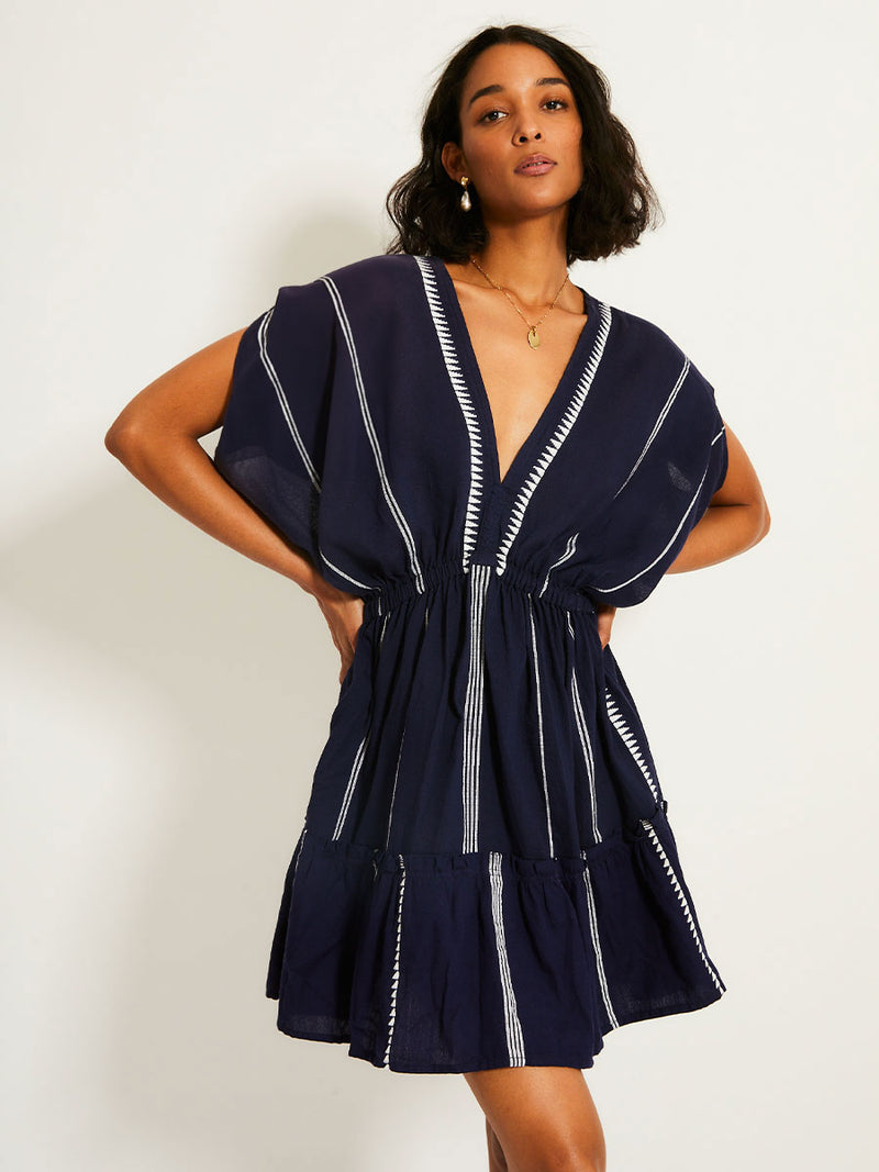 Woman standing wearing the Nunu short Plunge Neck in Navy blue with white stripes and graphic lines.