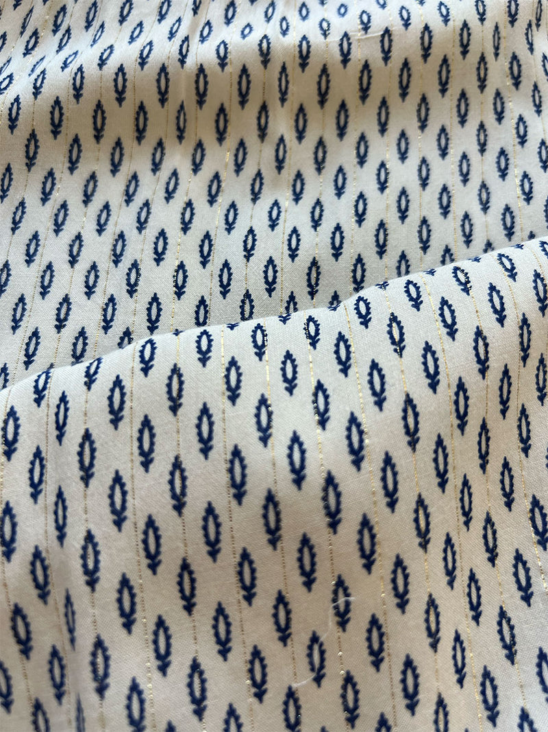 close up on lemlem wibi cream fabric featuring featuring a blue geometrical print on a soft cream background.